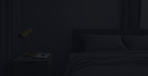 Una habitación tranquila y oscura con una libreta y un bolígrafo en una mesita de noche, junto a una cama bien hecha y sin pantallas a la vista